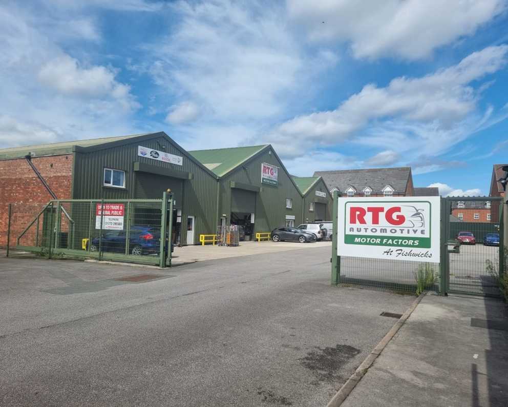 A group of warehouses with a sign in front of them that says RTG Automotive